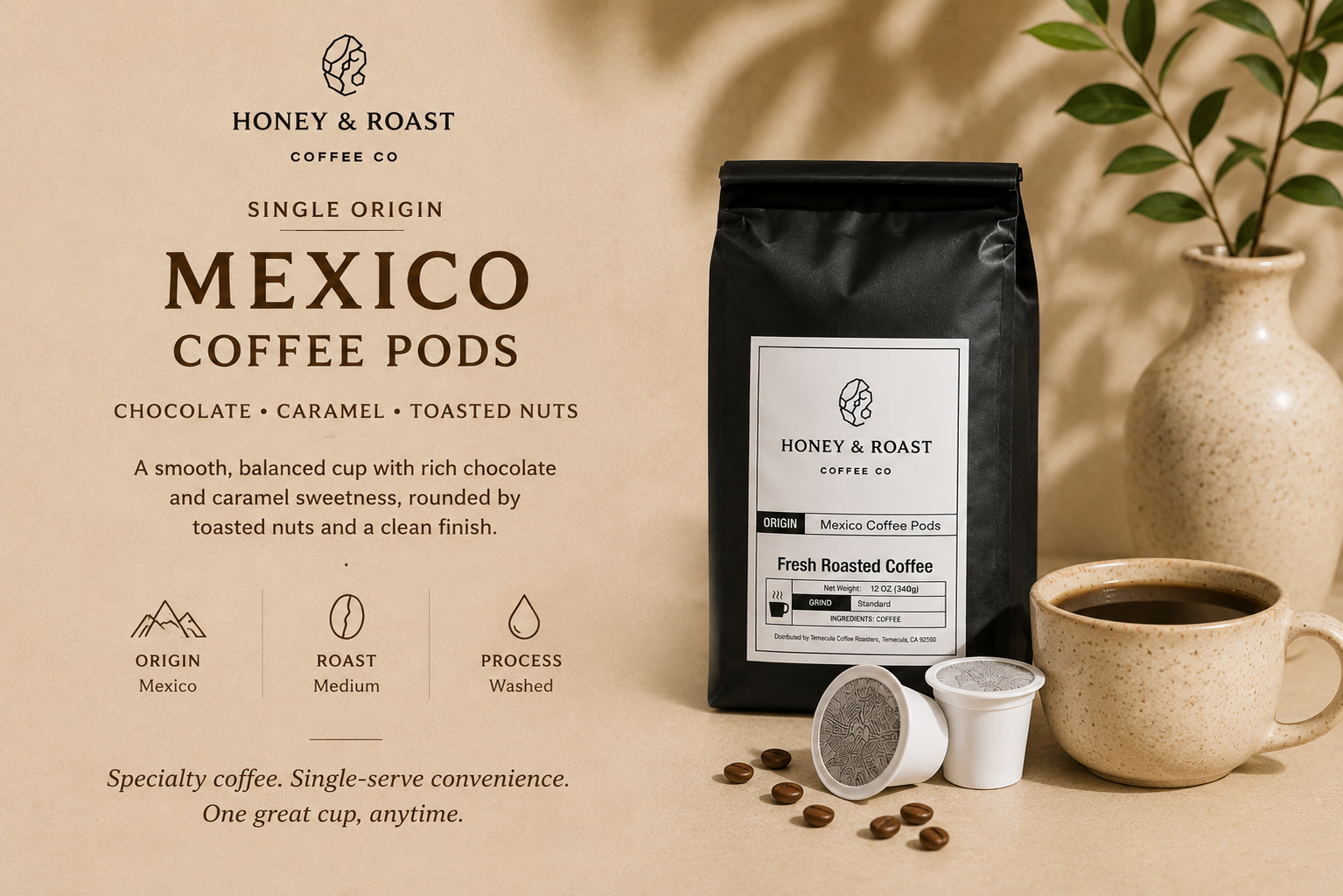 A bag of Honey & Roast Coffee Co. Mexico Coffee Pods stands on a beige surface beside a cup of coffee, coffee beans, and a ceramic vase with leaves.