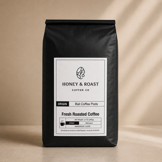 A black bag of Honey & Roast Coffee Co. Fresh Roasted Coffee, Ball Coffee Pods, standing upright on a beige surface with soft shadow overlays.