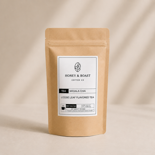 A kraft paper stand-up pouch of Honey & Roast Coffee Co. Masala Chai loose leaf flavored tea, set against a warm beige background with soft diagonal shadows.
