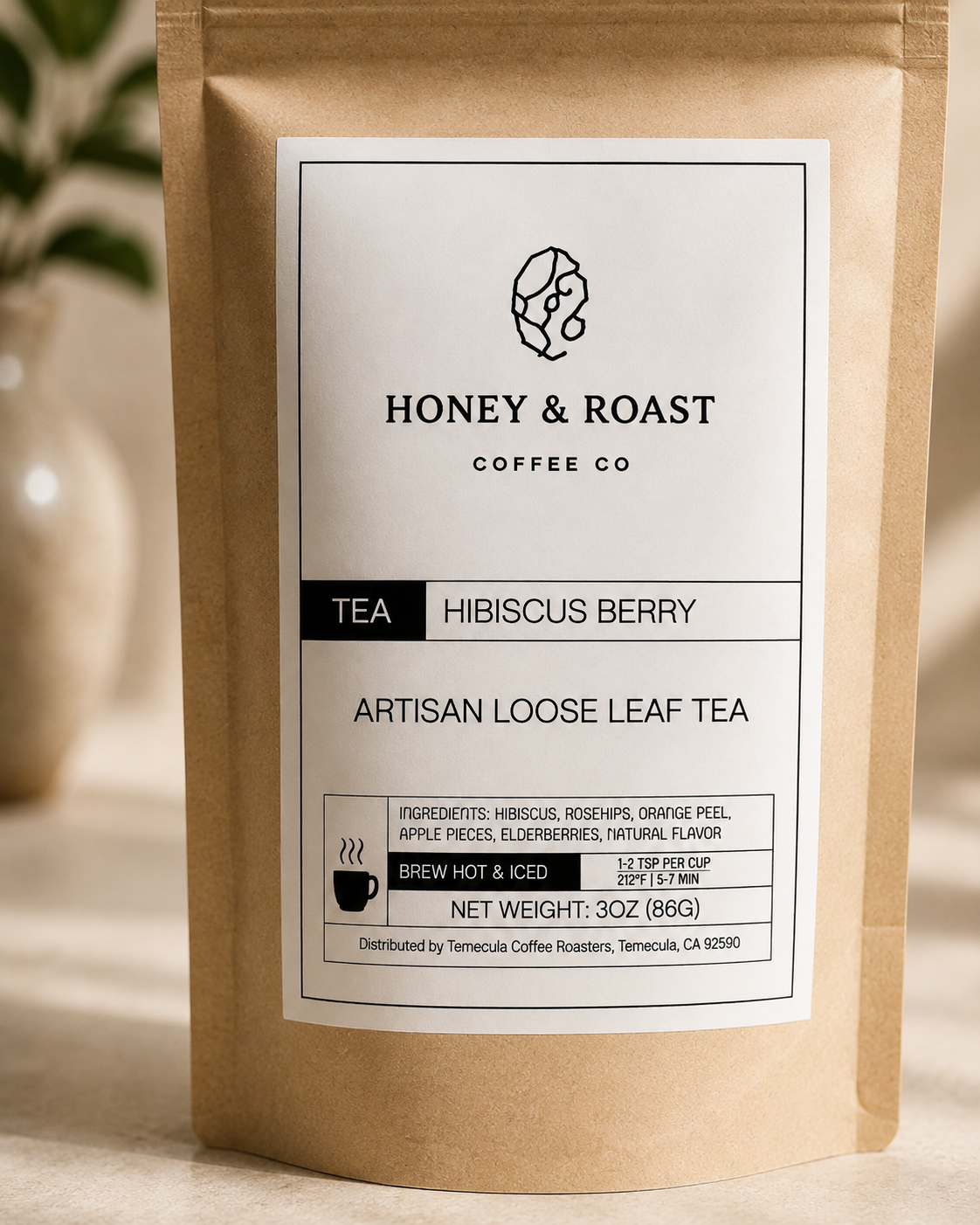 A 3 oz stand-up kraft paper pouch of Honey & Roast Coffee Co. artisan loose leaf tea, Hibiscus Berry, with a white label, set against a softly blurred warm background.